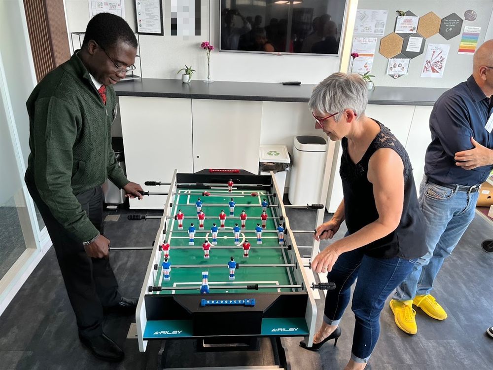 Partie de baby-foot entre collègues dans l’espace détente d’un coworking